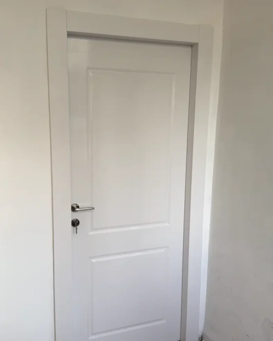 דלת פנים לבנה דו פנל עם משקוף תואם בהתקנה של MDOORS